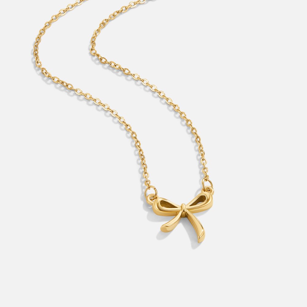 Serenity Bow Pendant Necklace, gold chain necklace laid flat, with a small bow pendant at the centre