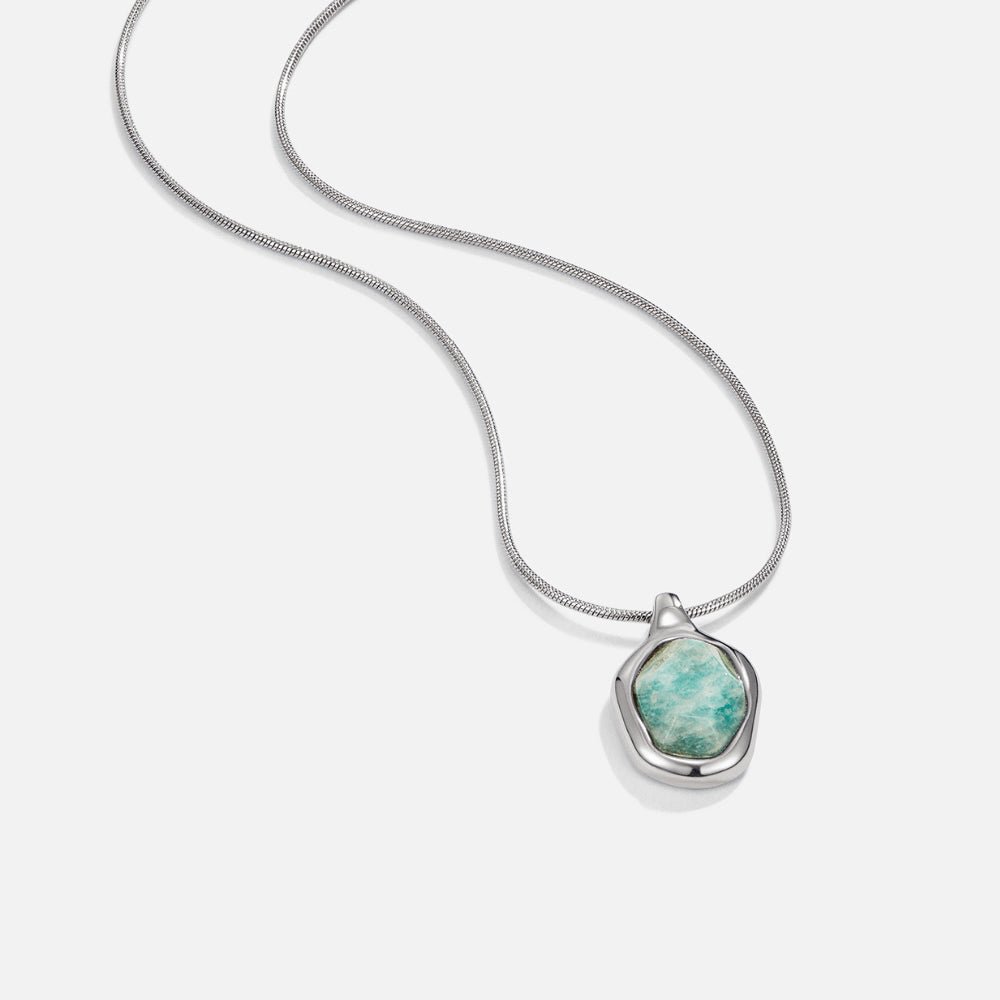 Silver Aquamarine Pendant Necklace, silver snake chain with a pendant of green-blue stone in a sculpted frame, on white