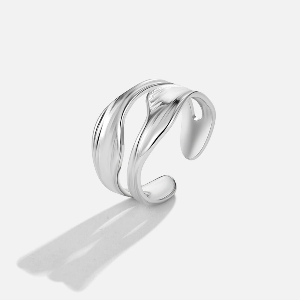Silver Penelope Ring, open wavy silver band on a plain light background, with a cast shadow