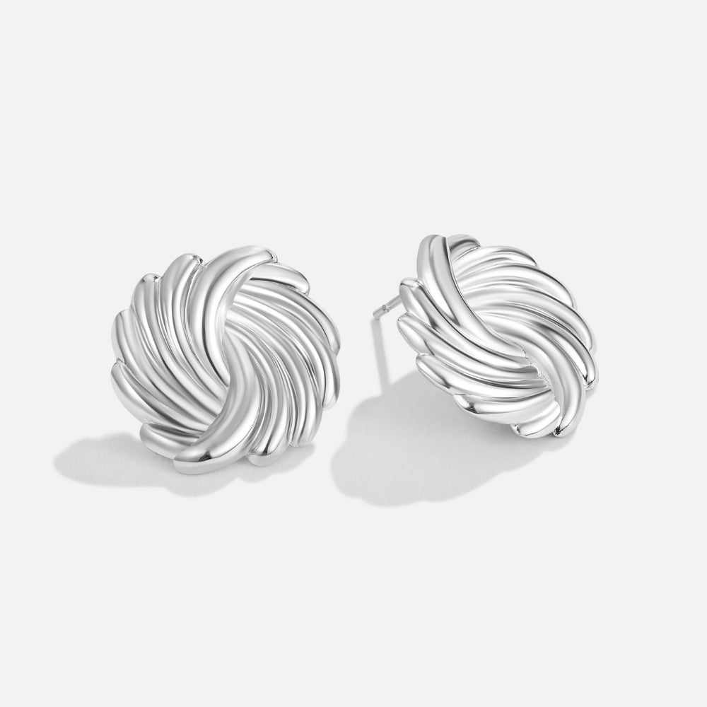 Silver Spiral Earrings, pair of polished silver swirl stud earrings on a plain white background