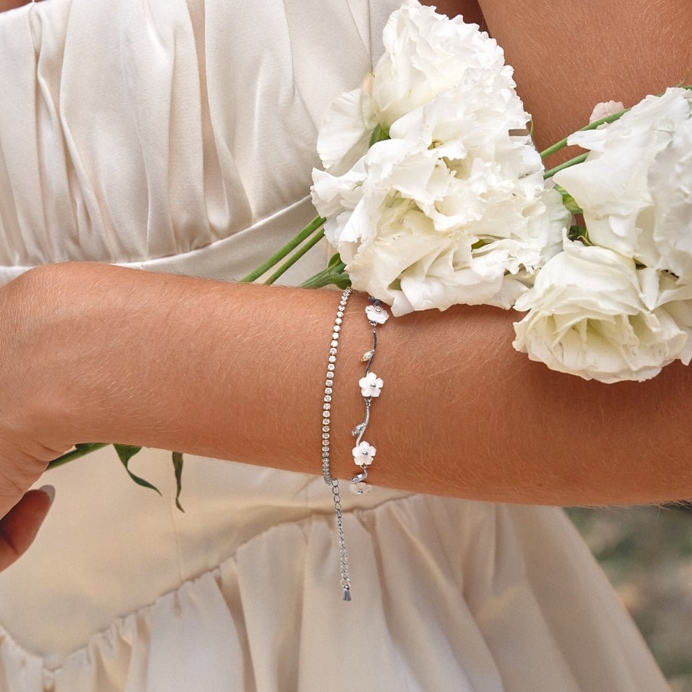 Silver White Pearl Blossom Bracelet, worn on a wrist with a silver chain bracelet, white