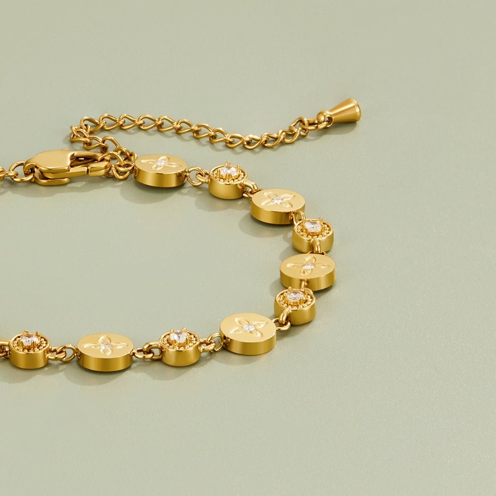 Spring Bloom Gold Bracelet, gold bracelet laid flat on sage green, with round discs and clear stones