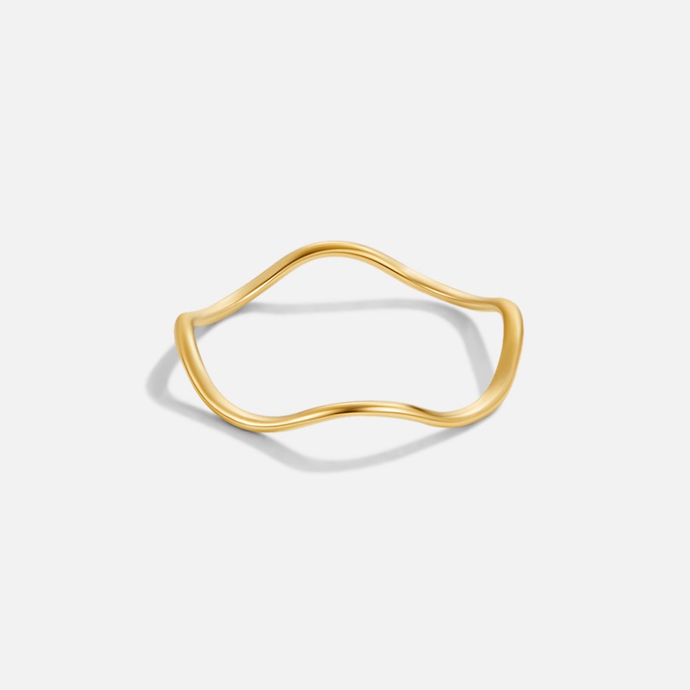 Tina Gold Stack Ring, wavy gold band on a plain light grey background, shown alone