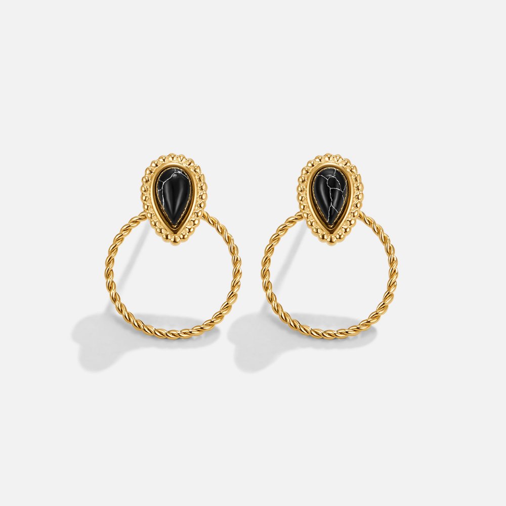 Tori Black Stone Earrings, a pair of gold earrings with black teardrop stones on white