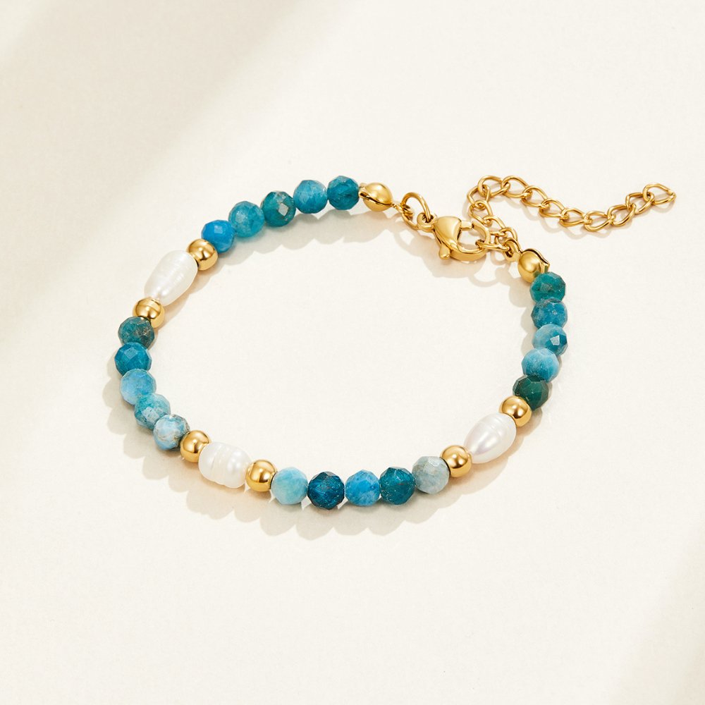 Turquoise Blue & Pearl Bead Bracelet, laid flat on a cream surface, blue beads with pearls and