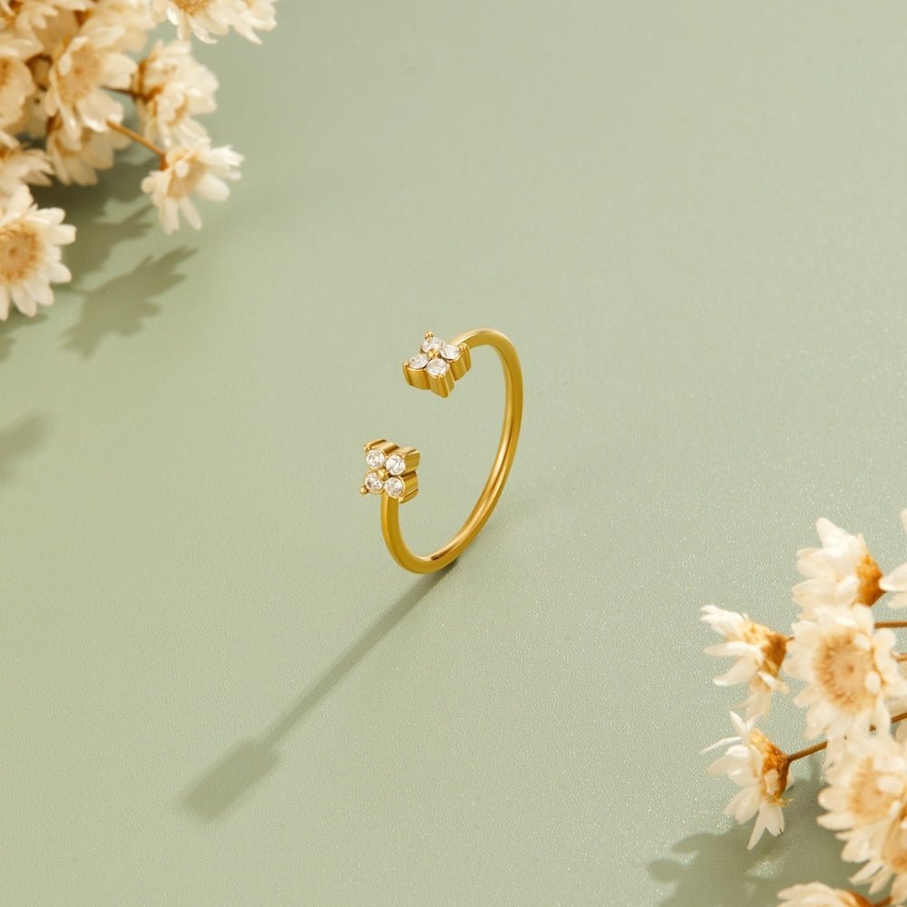 Twin Petal Gold Ring, open gold ring on sage green surface with dried flowers, cast shadow