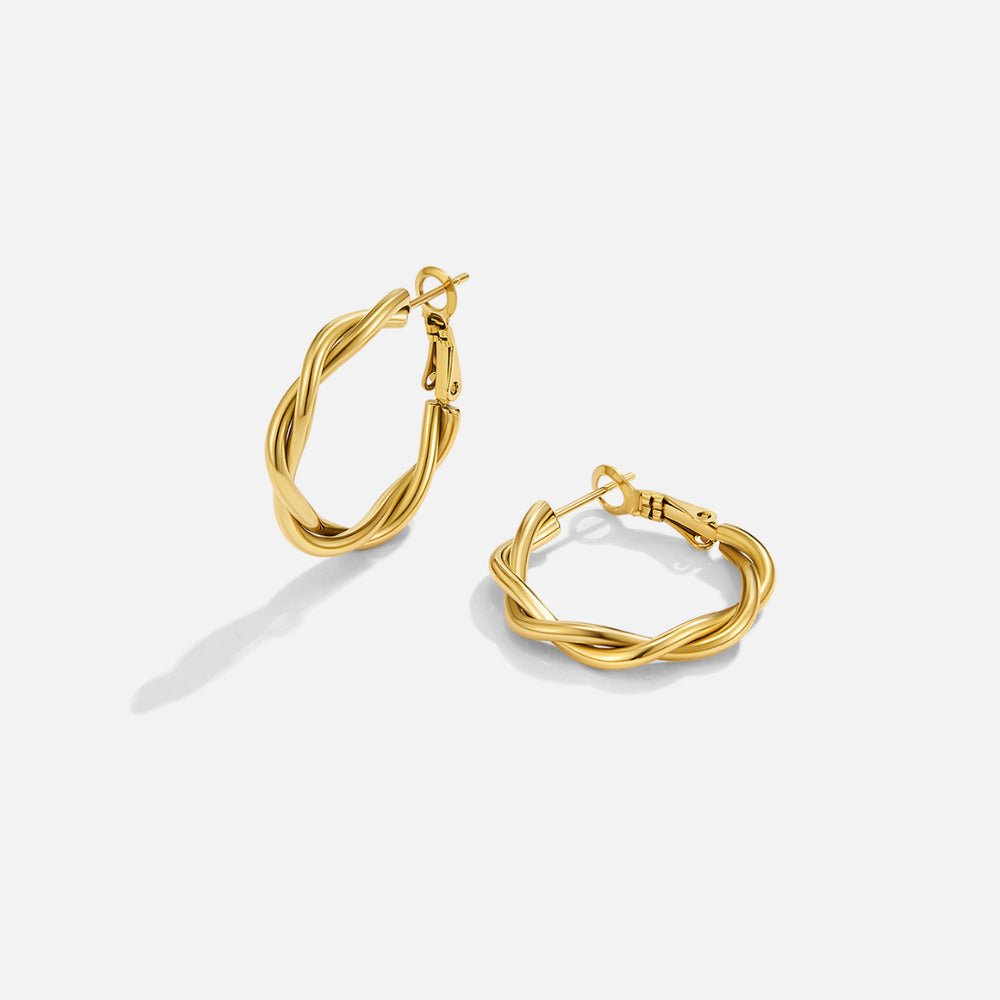 Twisted Celine Hoop Earrings, pair of twisted gold hoops on a plain white background