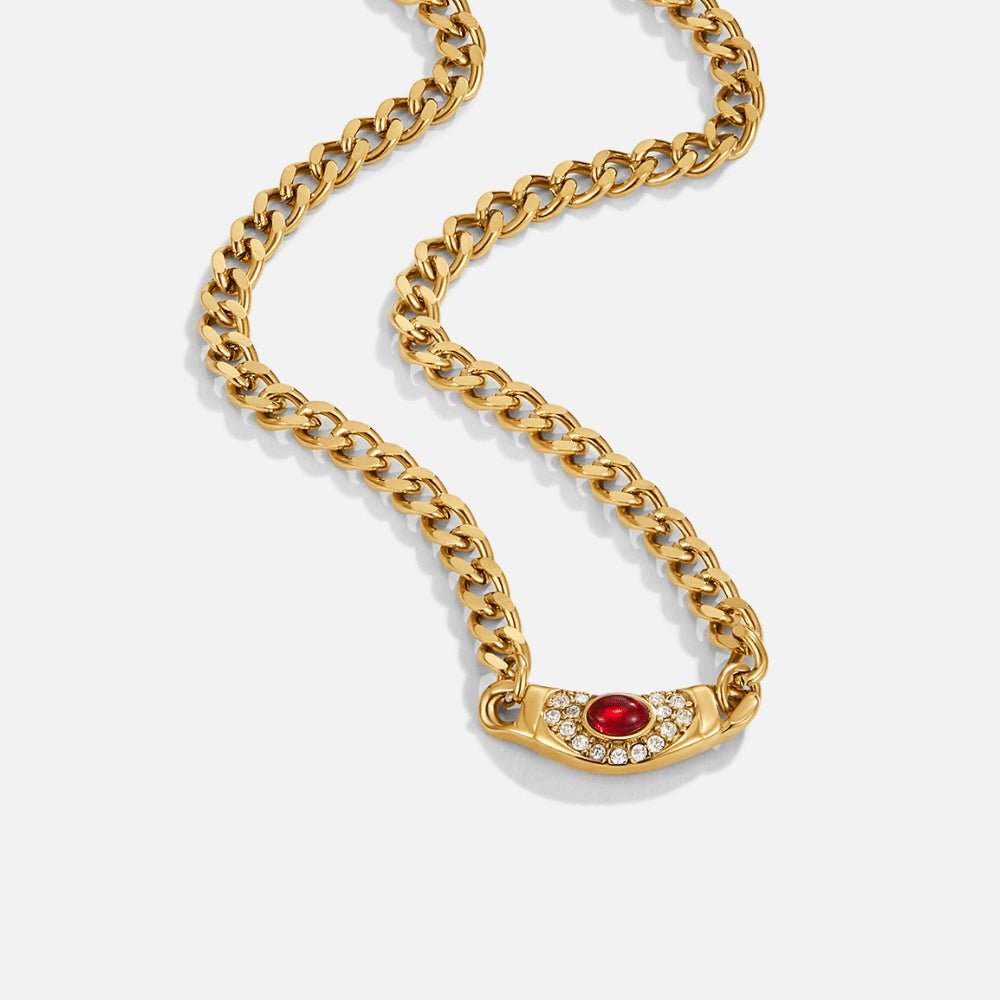 Vintage Cleopatra Gold Necklace, gold curb chain necklace laid flat on white, red stone pendant