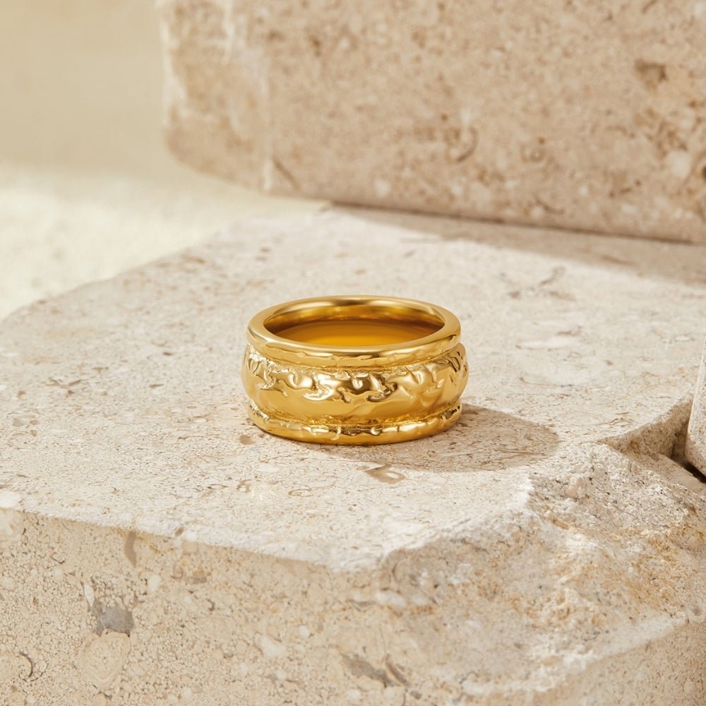 Vintage Elodie Gold Ring, standing upright on a stone ledge, gold with a textured band