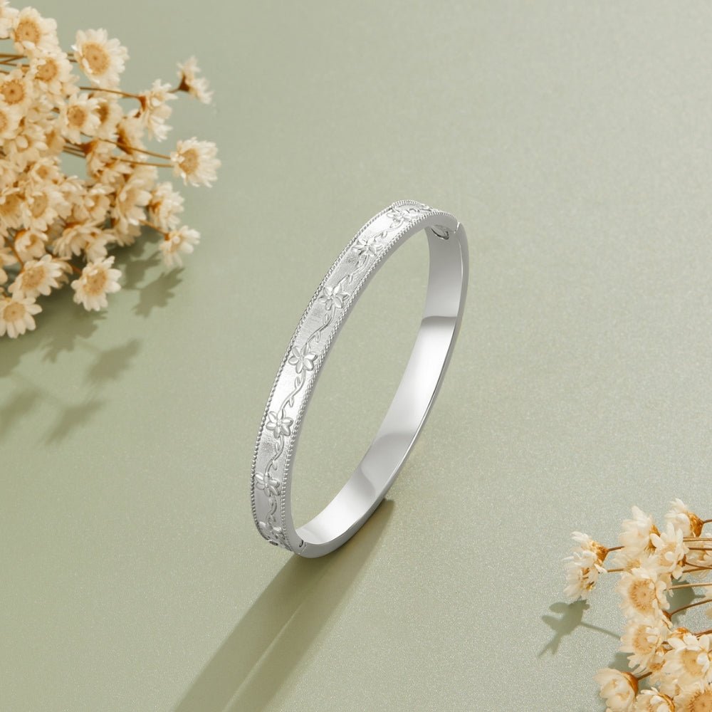 Vintage Silver Vine Bangle, standing upright on sage green surface beside dried flowers