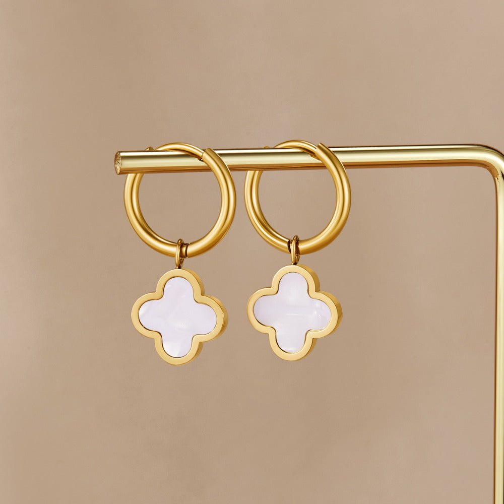 White Clover Hoop Earrings, hanging on a gold display rod, white clover charms with gold rims