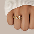 18K Gold Crystal Vine Ring, worn on a finger with a cream knit sleeve, gold leaf-and-vine setting