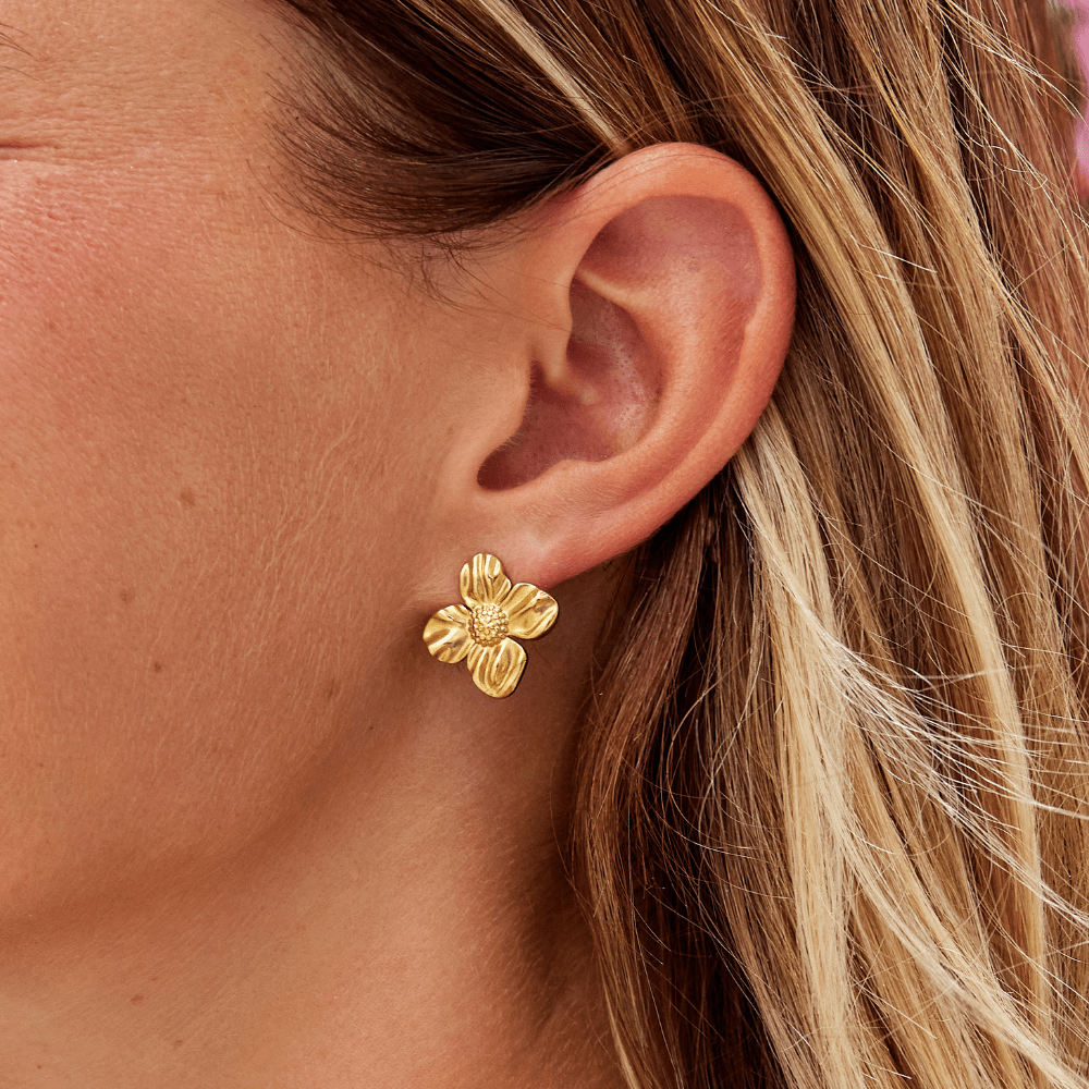 18K Gold Flower Earrings, worn on an ear, gold four-petal flower stud with textured centre