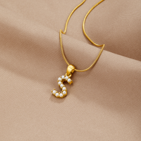 Letter Pearl Charm Necklace, gold necklace with pearl-set letter pendant on beige satin