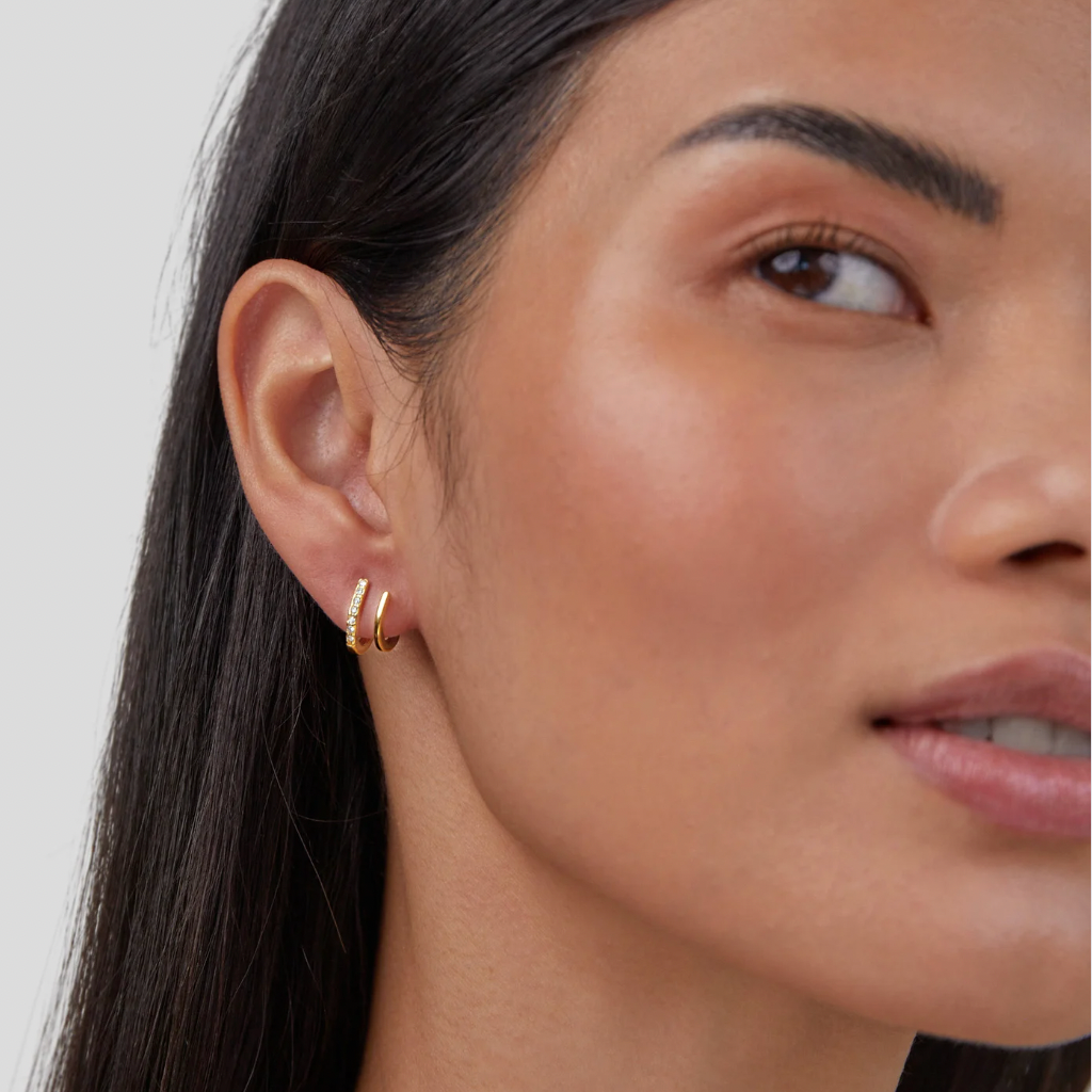 18K Gold & Crystal Claw Earrings, worn in a pierced ear, with a pavé hoop and a plain gold hoop