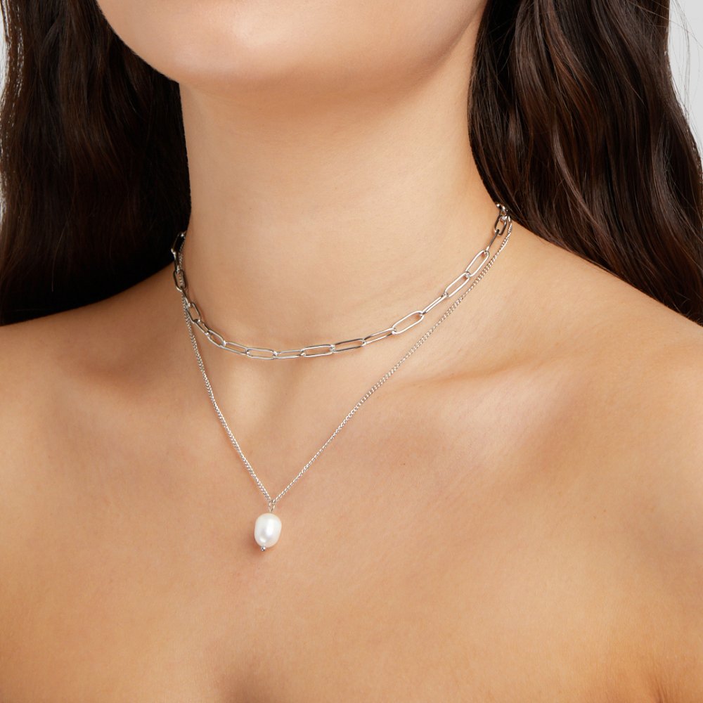 Angela Pearl Silver Necklace, worn on a neck layered with a chain and a pearl pendant