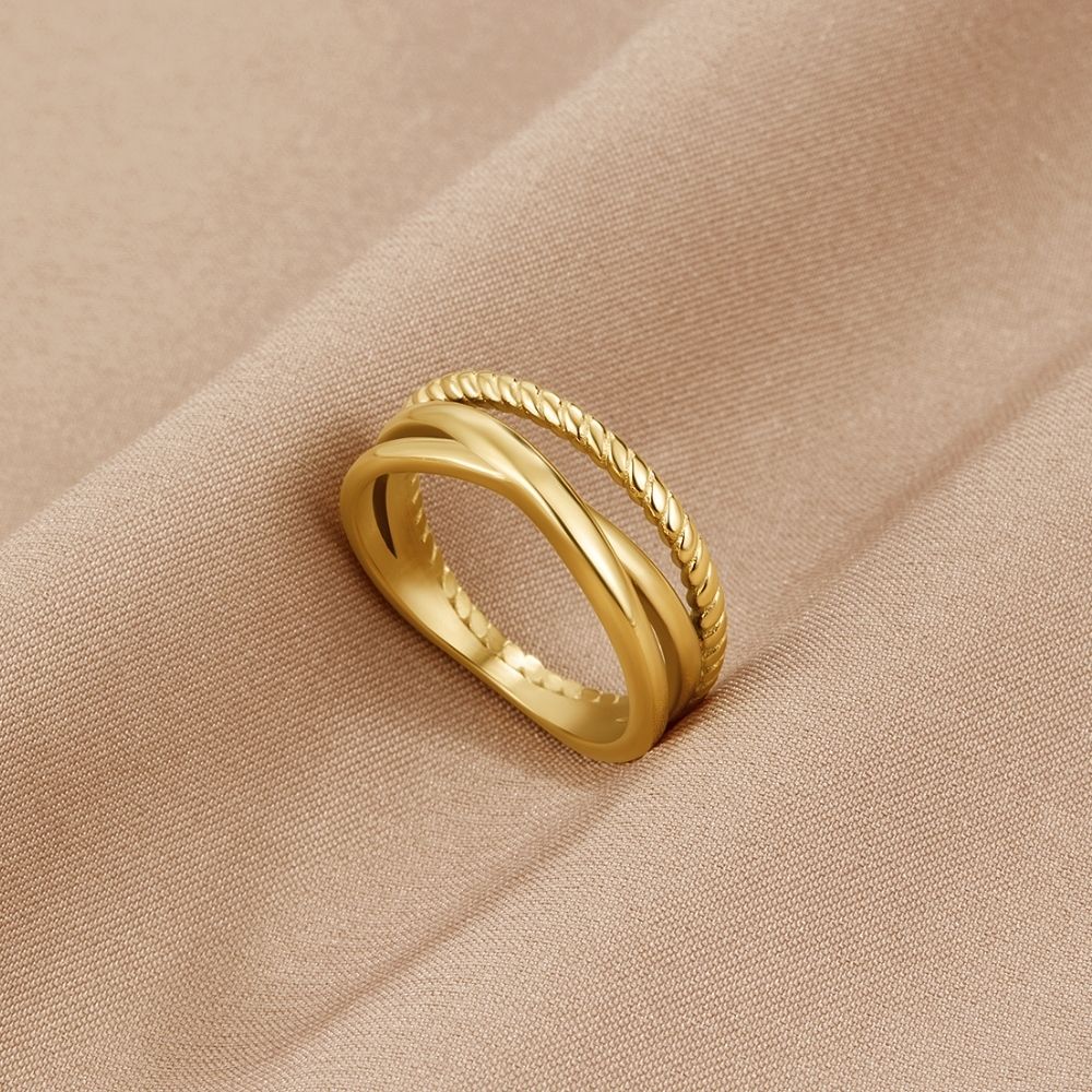 Ara Twisted Crossed Ring, lying on beige satin, gold crossed band with twisted rope edge