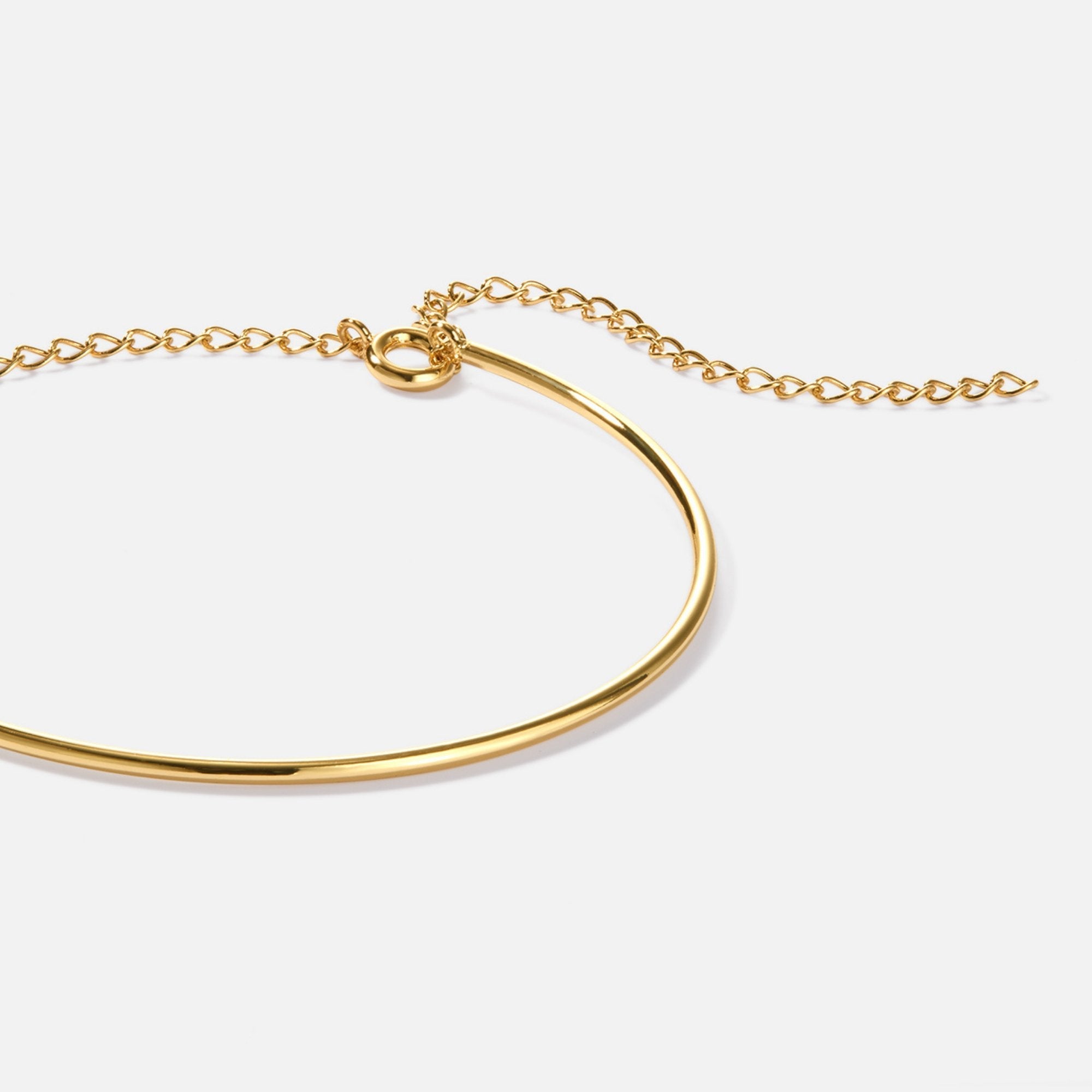 Aspen Gold Bracelet, close-up of a polished gold bangle with chain extender on white