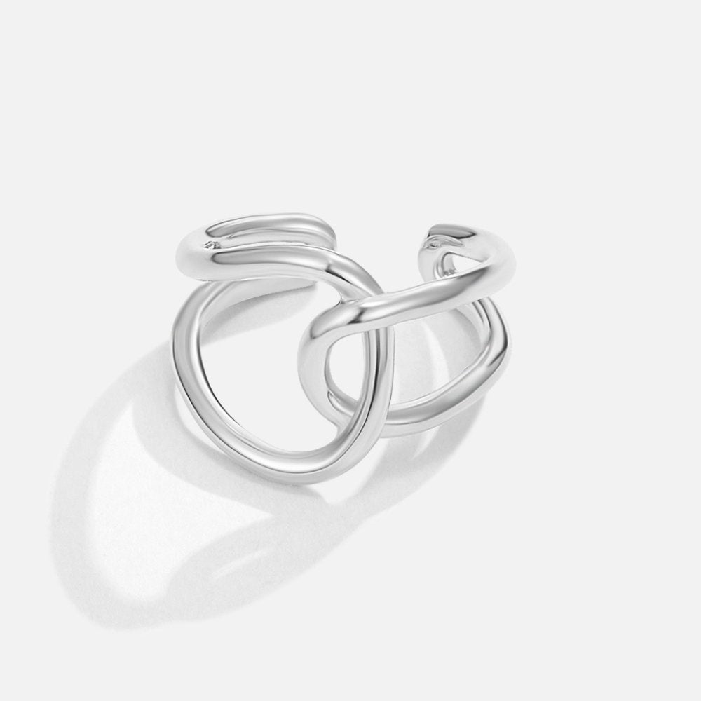 Astrid Silver Ring, polished silver ring of interlinked open loops on a pale background