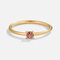 Birthstone 18K Gold Rings, standing alone on white, gold band with a small round red stone