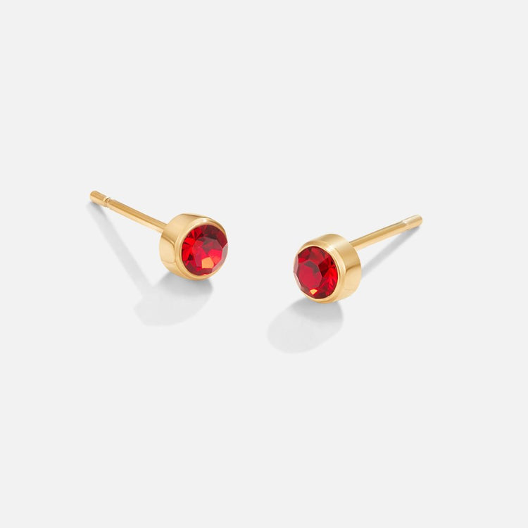 Birthstone Stud Earrings, a pair of gold stud earrings with red faceted stones on a plain background