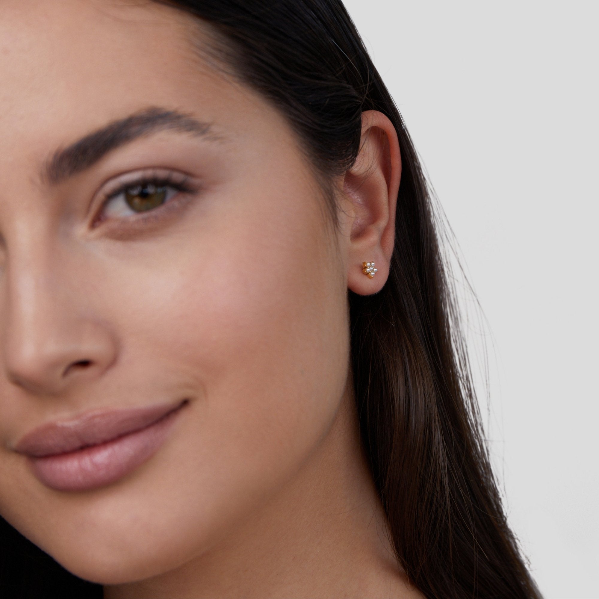 Blooming Flower Pearl Earrings, worn in one ear on a model with long dark hair