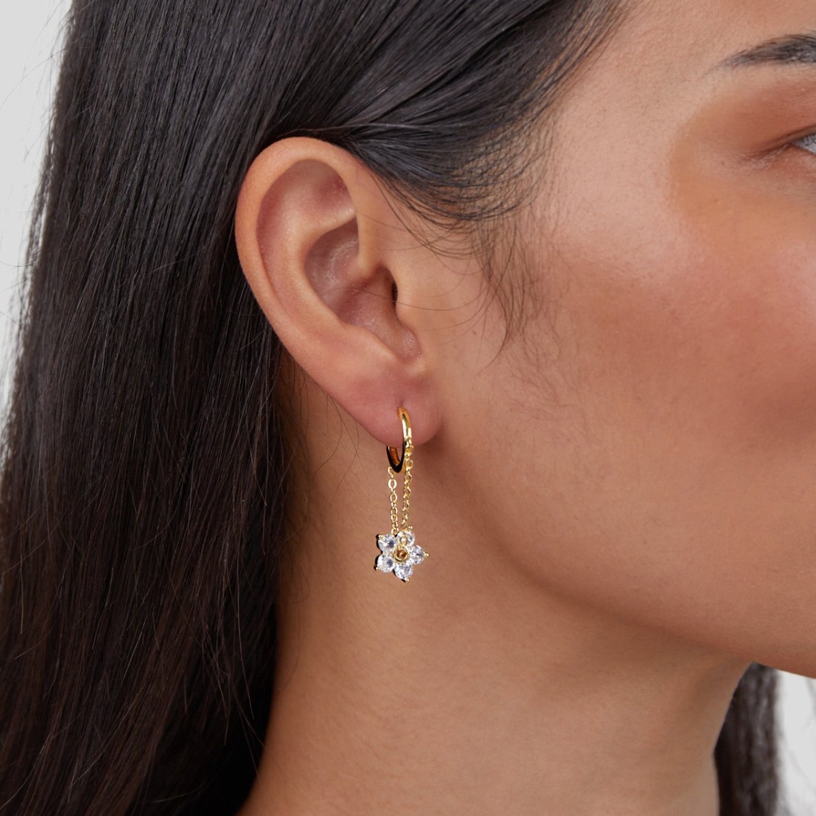 Blooming Petal Crystal Earrings, worn on an ear, gold hoop with a crystal flower charm