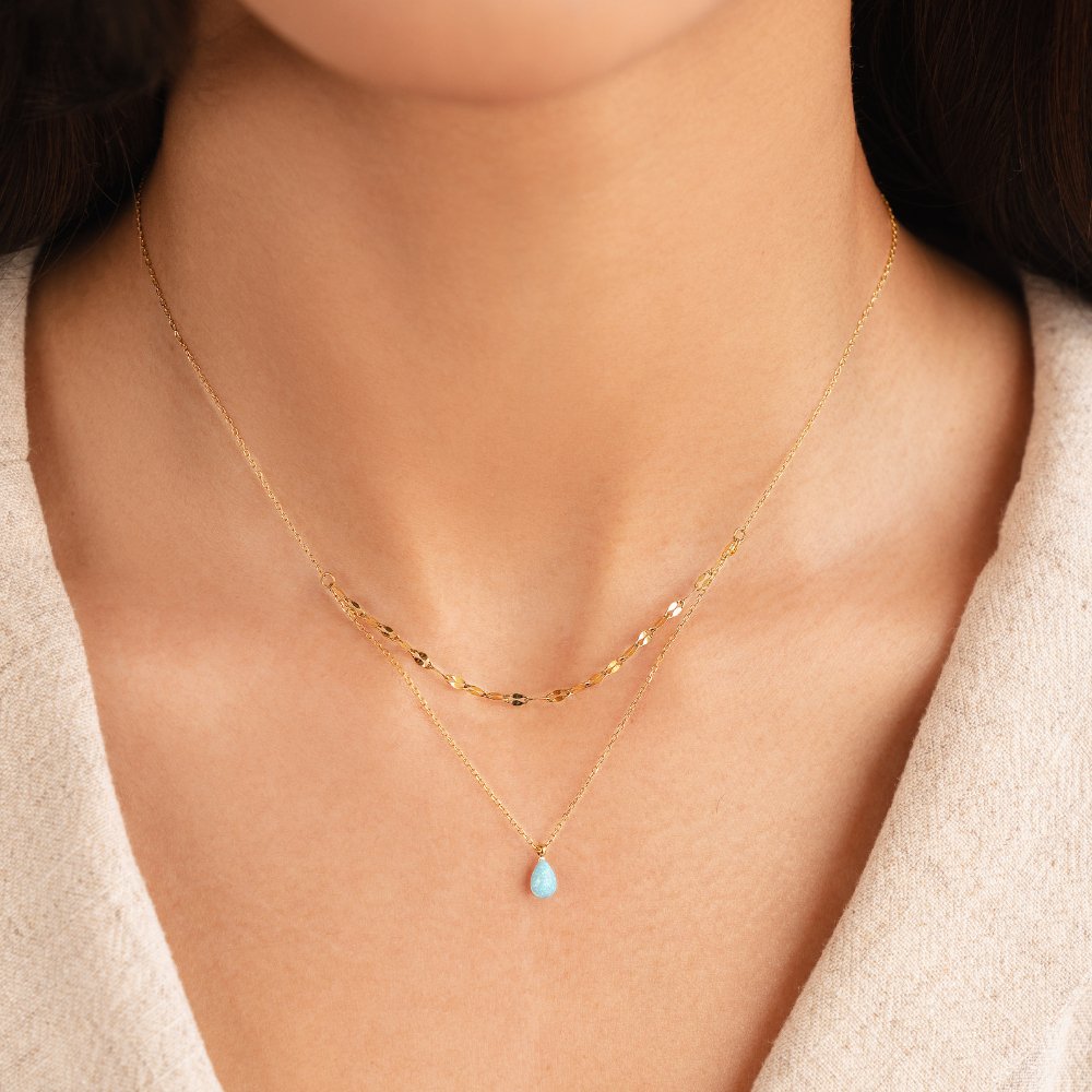 Blue Opal Teardrop Layered Necklace, worn on a neck with a beige top, layered with a gold chain