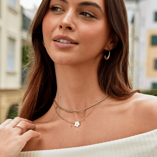 Free Calla Gold Twisted Chain Necklace, worn on a model with a gold hoop earring and flower pendant