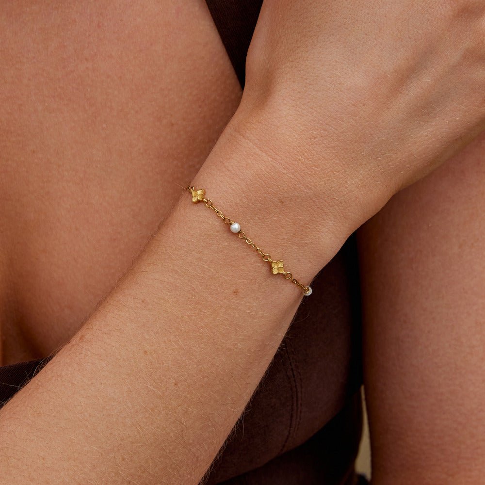 Camila Petal Bracelet, worn on a wrist, gold chain with a small pearl