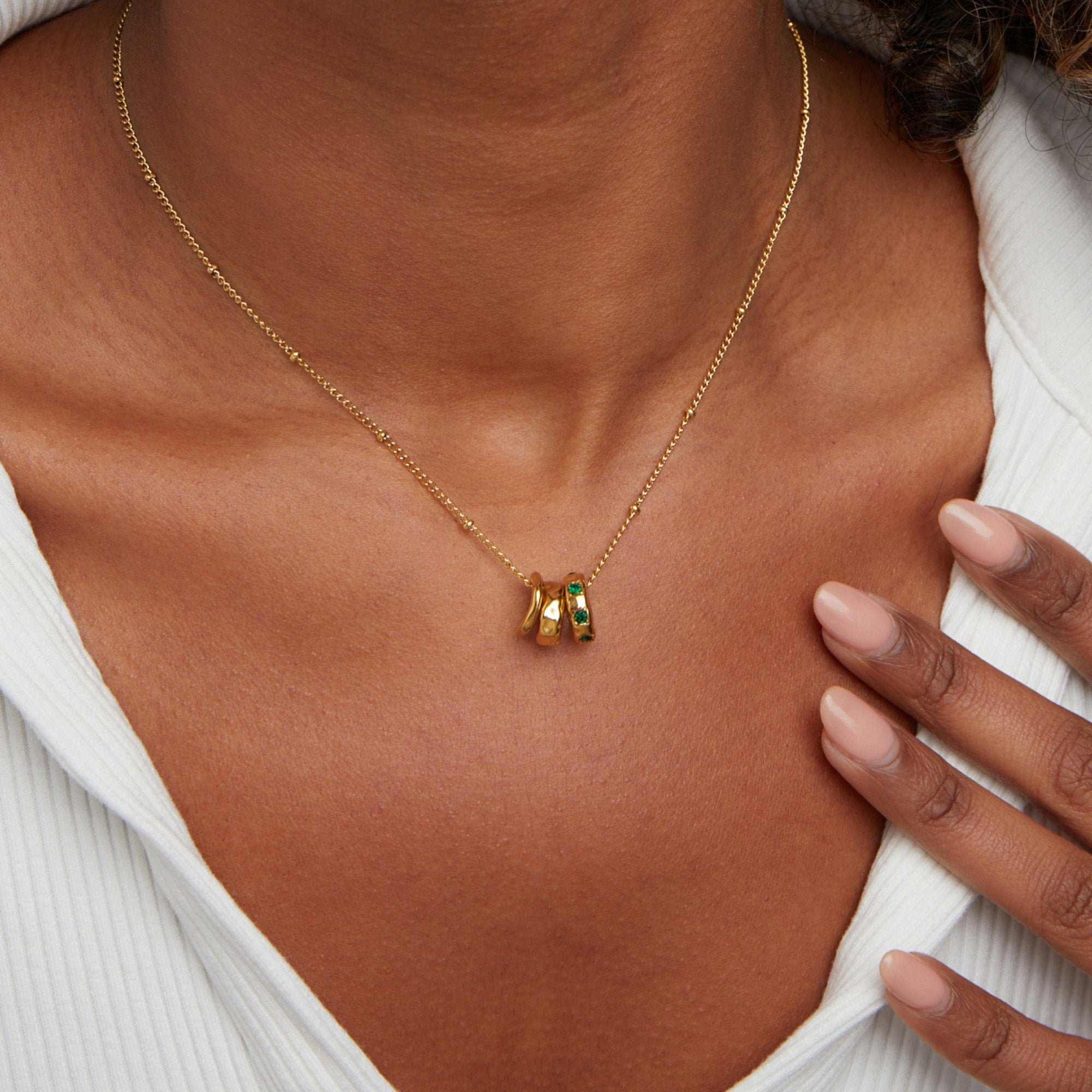 Camilla Pendant Necklace, worn on a neck with a white ribbed top, gold with green stone