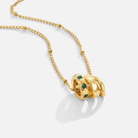 Camilla Pendant Necklace, gold chain with three stacked rings, green stones on one, on white