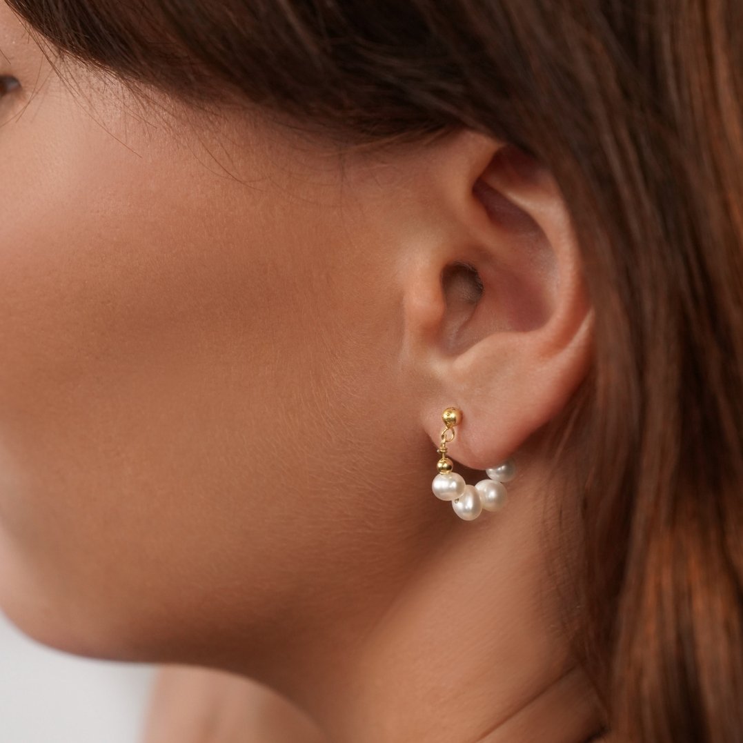 Celine Pearl Hoop Earrings, worn on an ear, small gold post with pearl hoop below