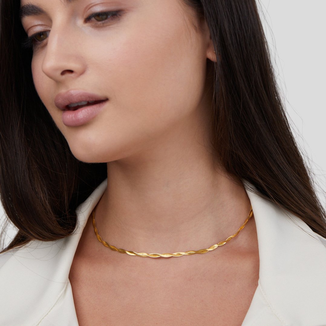 Chiara Twist Snake Chain Necklace, worn at the neck on a model in a white top, gold twisted chain