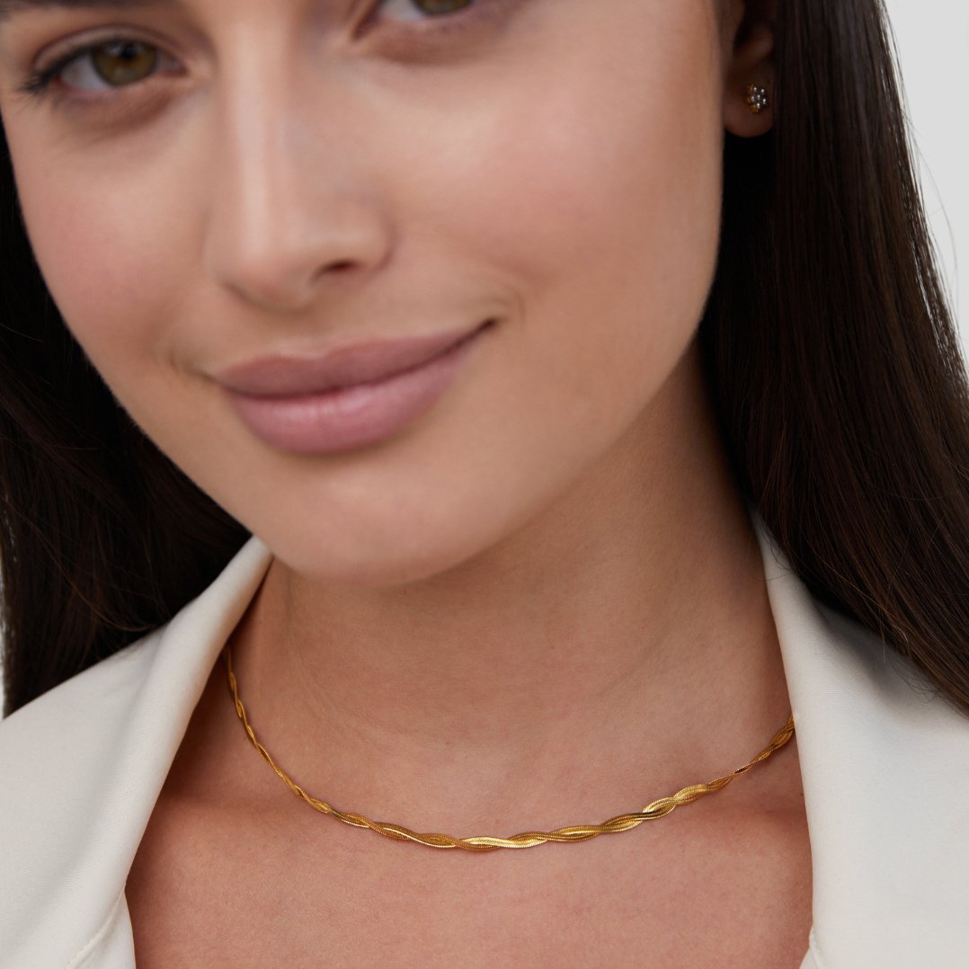 Chiara Twist Snake Chain Necklace, worn on a woman with a white jacket and stud earring