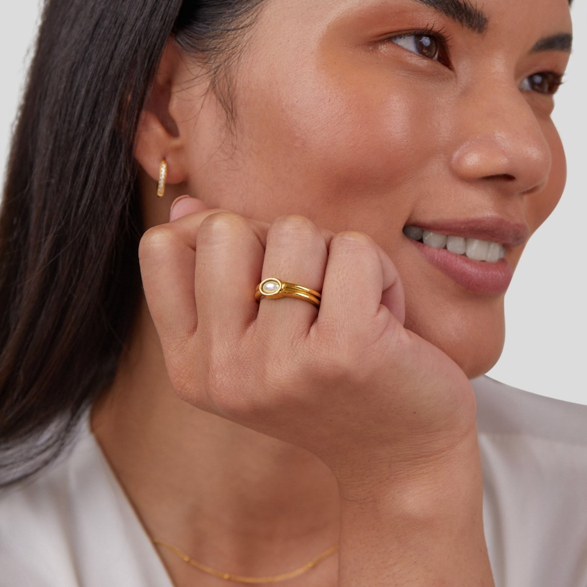 Chunky Pearl 18K Gold Ring, worn on a hand resting against a smiling face, gold band with pearl
