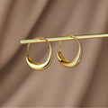 Classic Drop Hoop Earrings, pair of gold crescent hoop earrings hanging from a gold rod