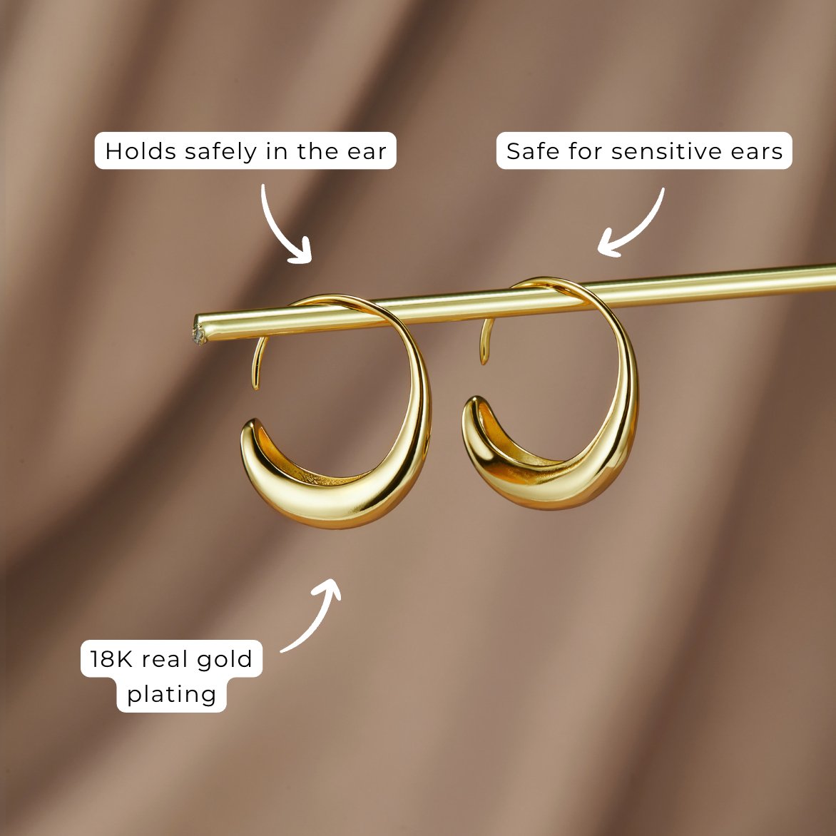 Classic Drop Hoop Earrings, two gold hoop earrings hanging on a gold rod against a brown backdrop, with callout labels