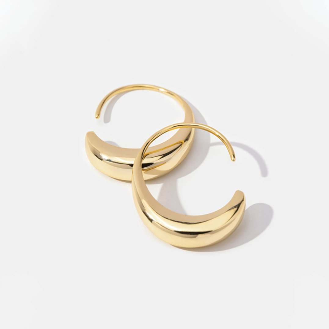 Classic Drop Hoop Earrings, two polished gold hoop earrings on a white background, one overlapping the other