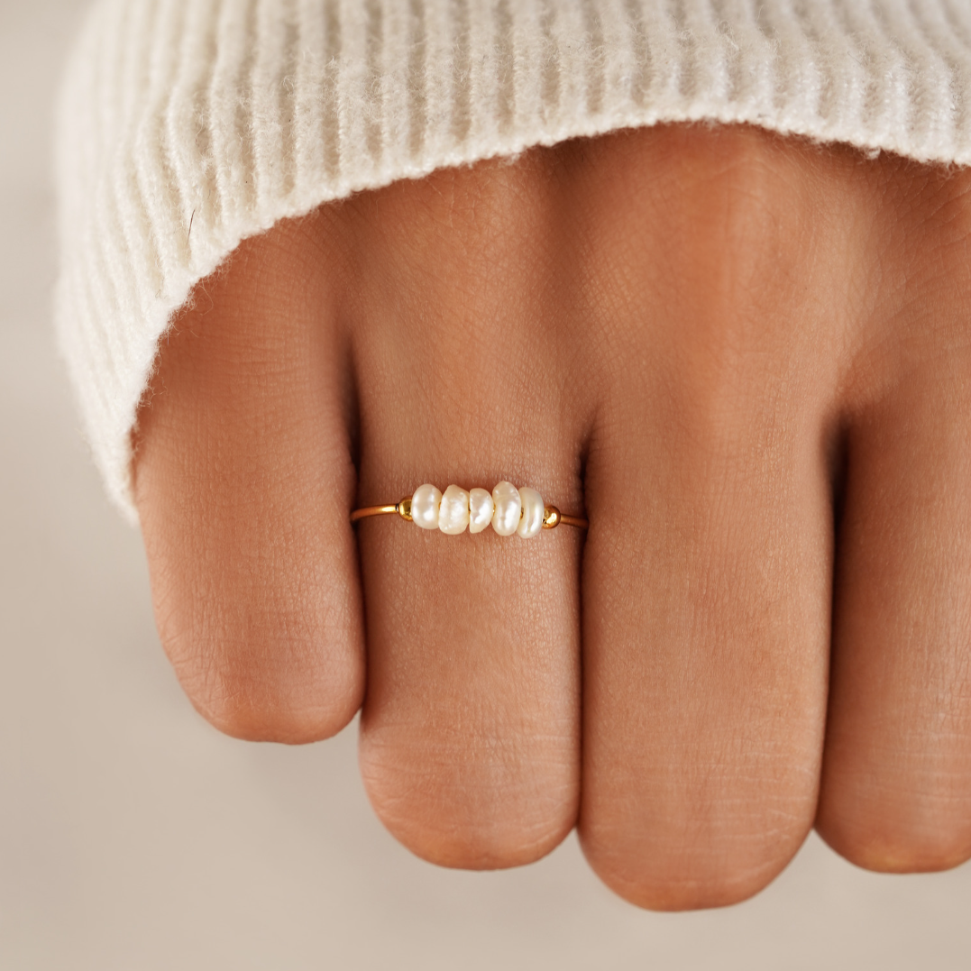 Classic Freshwater Pearl Ring, worn on a finger with a cream knit sleeve, close-up on pearls