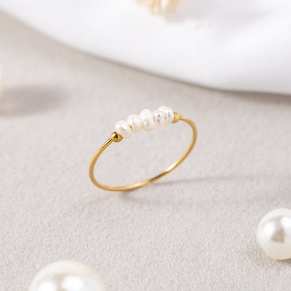 Classic Freshwater Pearl Ring, standing on a grey surface with loose pearls nearby