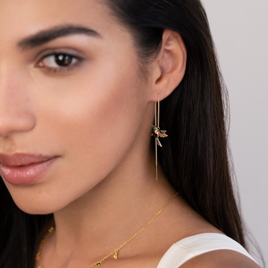 Crystal Hummingbird Tassel Earrings, worn on an ear, close-up with gold chains and enamel bird charm