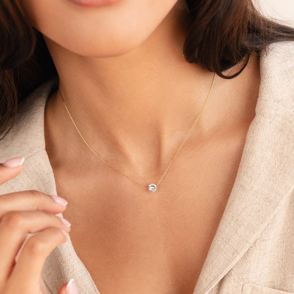 Dainty Round Crystal Necklace, worn on a neck with a beige linen jacket, fine gold chain