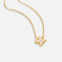Dalia White Iris Clover Necklace, gold chain necklace laid flat with clover pendant, white