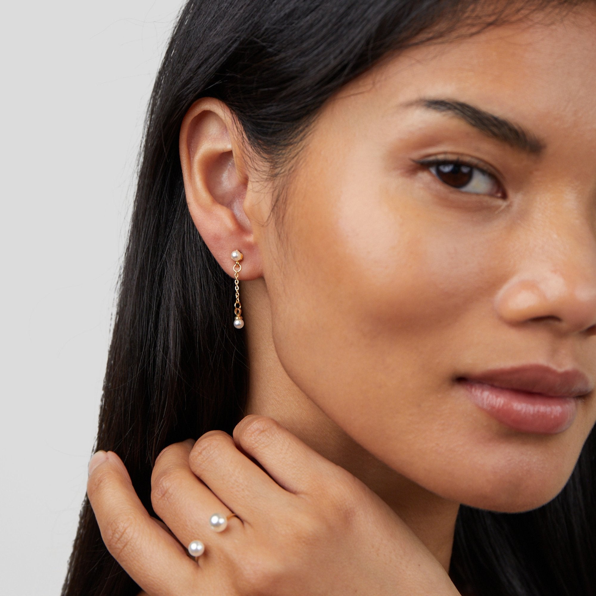 Durya Double Pearl Wrap Ring, worn on a model's hand with a pearl drop earring