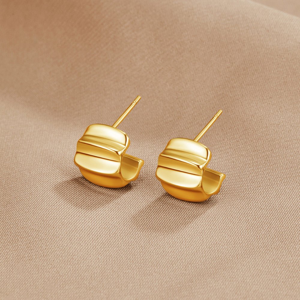 Elsa Mini Wave Hoop Earrings, a pair of gold earrings lying on beige satin fabric