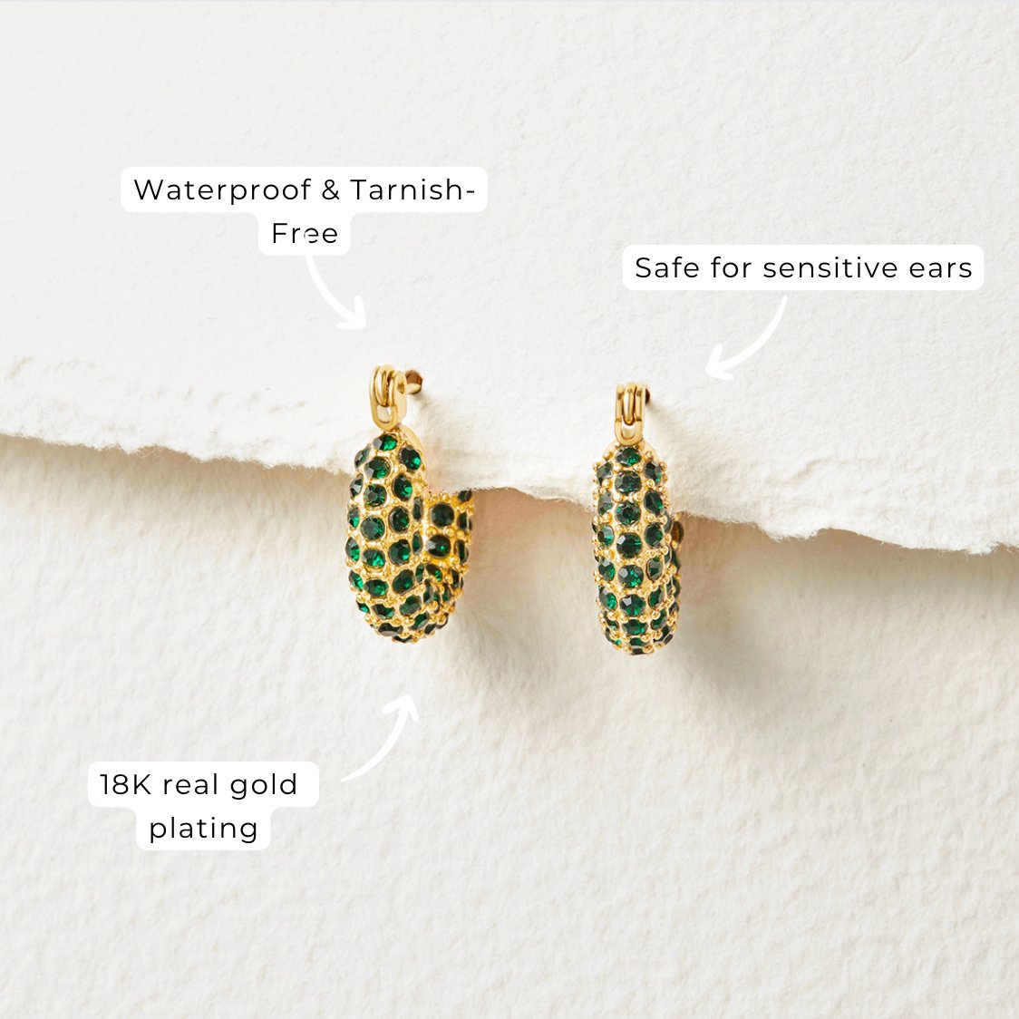 Emerald Beauty Hoop Earrings, pair of green crystal-studded gold hoops on white paper