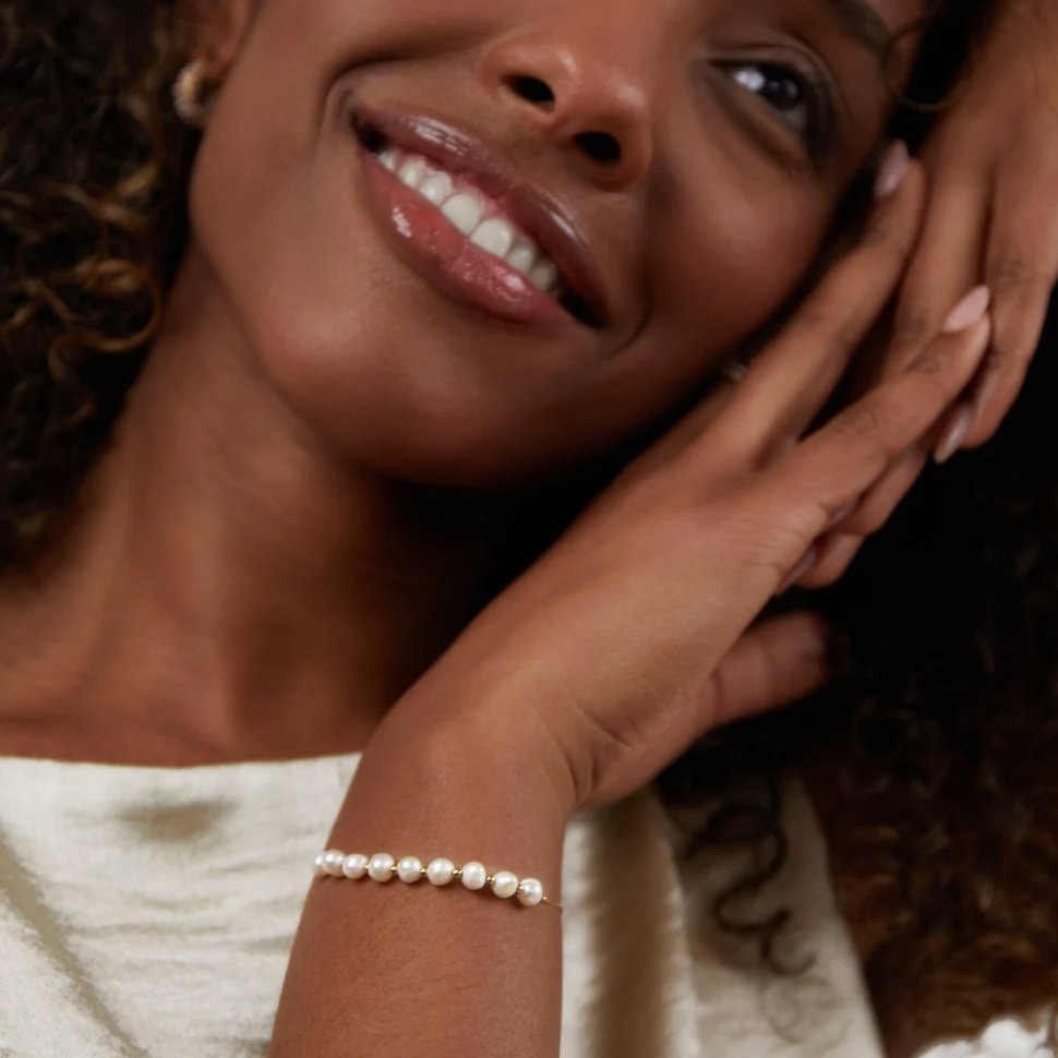 Eva Freshwater Pearl Bracelet, worn on a wrist with a hand resting near a smiling face