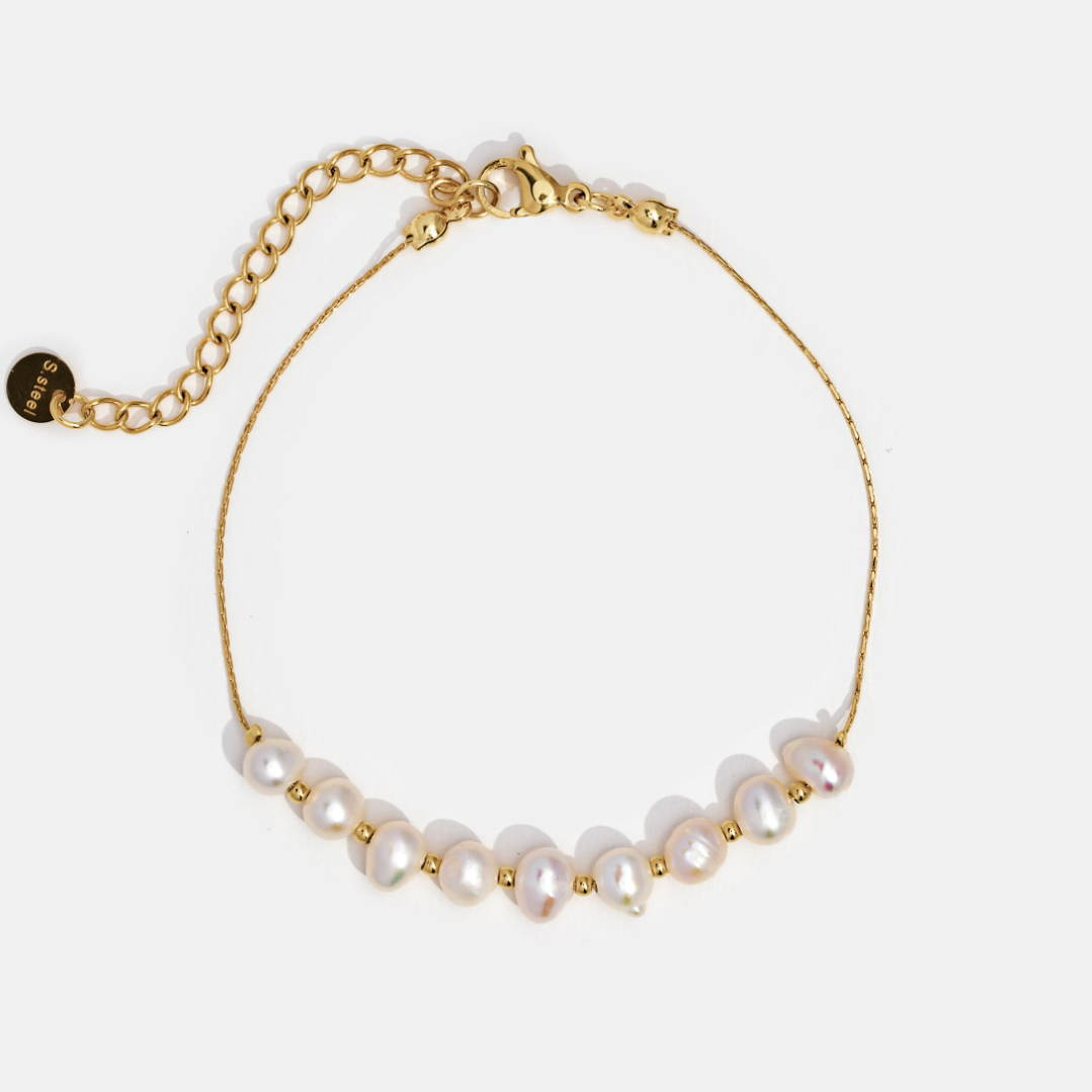 Eva Freshwater Pearl Bracelet, flat lay of a gold chain bracelet with pearls on white