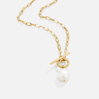 Eva Freshwater Pearl Gold Necklace, gold chain necklace laid flat on pale grey, pearl pendant